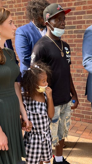 Quinton Burns, of Baltimore, stands with daughter, Kennedi, at a press conference announcing a federal discrimination lawsuit against Sesame Place July 27, 2022 in Philadelphia.