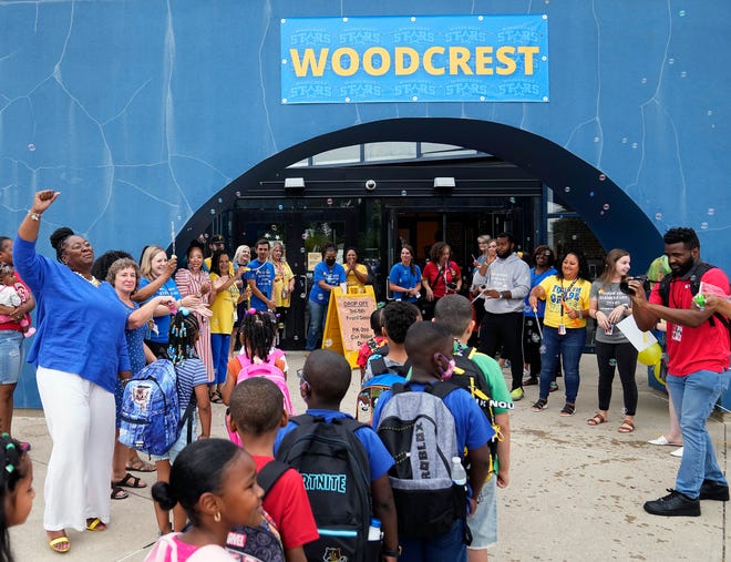 Jul 27, 2022; Columbus, Ohio, USA; Woodcrest Elementary principal Yolonda Cooper, left, cheers on her students as they wait to enter the school on the first day back to school on July 27, 2022. Woodcrest Elementary is the only Columbus City Schools year-round school. 