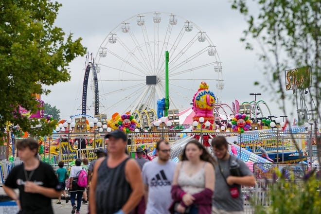 Visitors walk through the rides in the midway on July 27, opening day of the Ohio State Fair in Columbus.