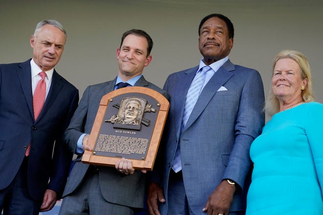 Hall of Fame baseball player Dave Winfield, second from right, stands next to inductee Bud Fowler's plaque held by Josh Rawitch, second from left, president of the National Baseball Hall of Fame and Museum, along with Rob Manfred, left, commissioner of Major League Baseball, and Jane Forbes Clark, right, chairman of the board of directors of the National Baseball Hall of Fame and Museum during the Hall of Fame induction ceremony Sunday, July 24, 2022, at the Clark Sports Center in Cooperstown, N.Y.