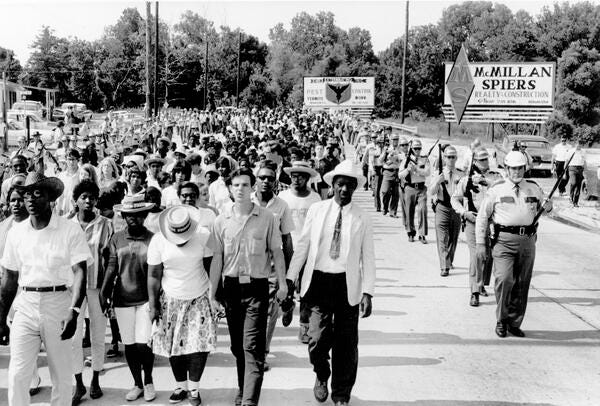 Bogalusa civil rights march on July 12, 1965. Reverend R. Brown on far right in white hat. Deacon for Defense Cleotha Guy on far left in straw hat. Liz Griffin and Marvin Austin behind Cleotha Guy.