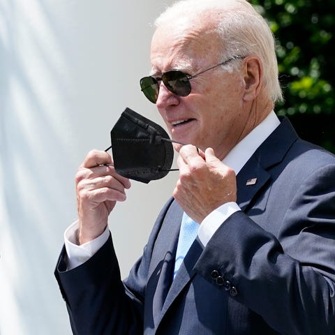 President Joe Biden takes off his mask as he start