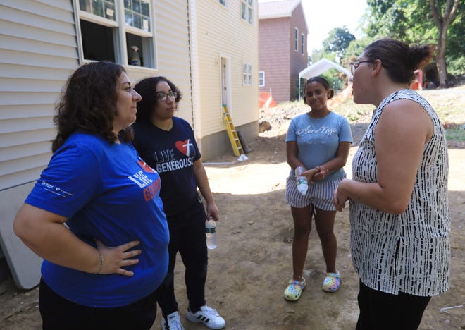 From left, Kimberlee Girolamo, Narissa Walker and Aaliyah Victor speak with Habitat for Humanity of Dutchess County's development director, Jessica Miuccio outside their home in Wappingers Falls on July 28, 2022. Girolamo and her 3 daughters are recipients of a Habitat for Humanity home and will be moving in to the house in early August.