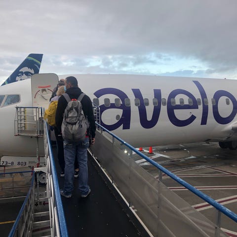 Passengers board an Avelo Airlines flight at Holly