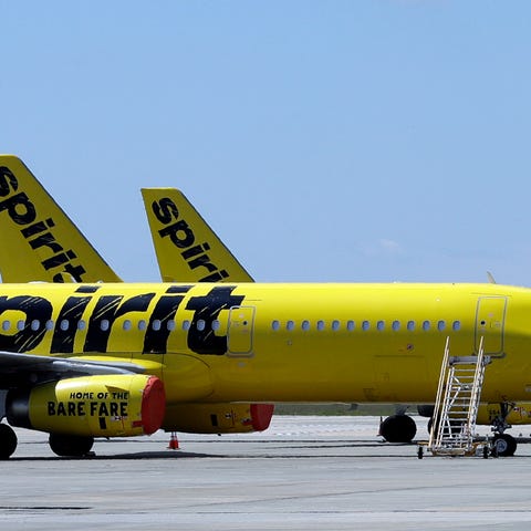 A line of Spirit Airlines jets sit on the tarmac a