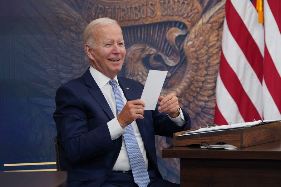 US President Joe Biden reacts to a note given to him saying that the CHIPS-plus bill has passed the House during a meeting with CEOs about the economy in the South Court Auditorium of the Eisenhower Executive Office Building, next to the White House, in Washington, DC on July 28, 2022. The $280 billion industrial policy was passed the Senate on Wednesday with rare bipartisan support and will boost domestic production of semiconductors, the in-demand microchips that power everything from smartphones to cars   to weapons.