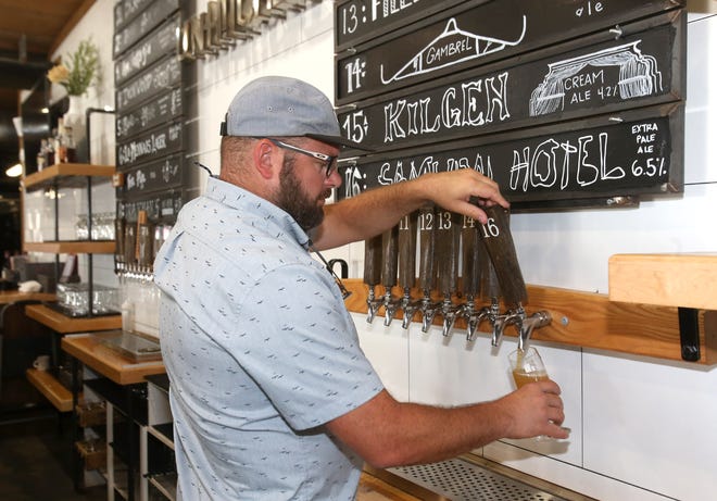 Adam Longacre, owner of UnHitched Brewing Co., pours a beer at his business in Louisville on Thursday, July 28, 2022.