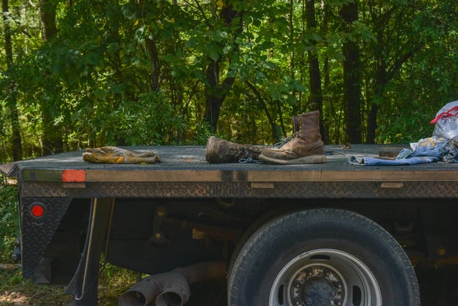 Workers' discarded boots and gloves lay on a truckbed outside of an oil well storage facility after an oil tank explosion was reported in Flora, Miss., Friday, July 29, 2022. Six people were seriously injured, two of whom were airlifted to local hospitals.