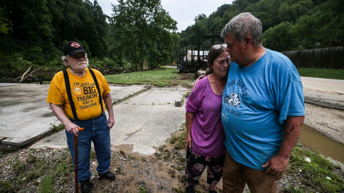 Pastor Pete Youmans consoles a tearful Debby Miniard as her father Charles Blankenship stands near where his garage used to be in Perry County. Blankenship lost everything -- his trailer home, garage, family photos -- after torrential rain caused flash flooding in Eastern Kentucky Thursday morning.  July 28, 2022