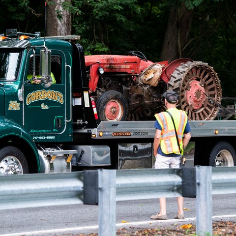 A flatbed tow truck removes a Massey Ferguson 65 t