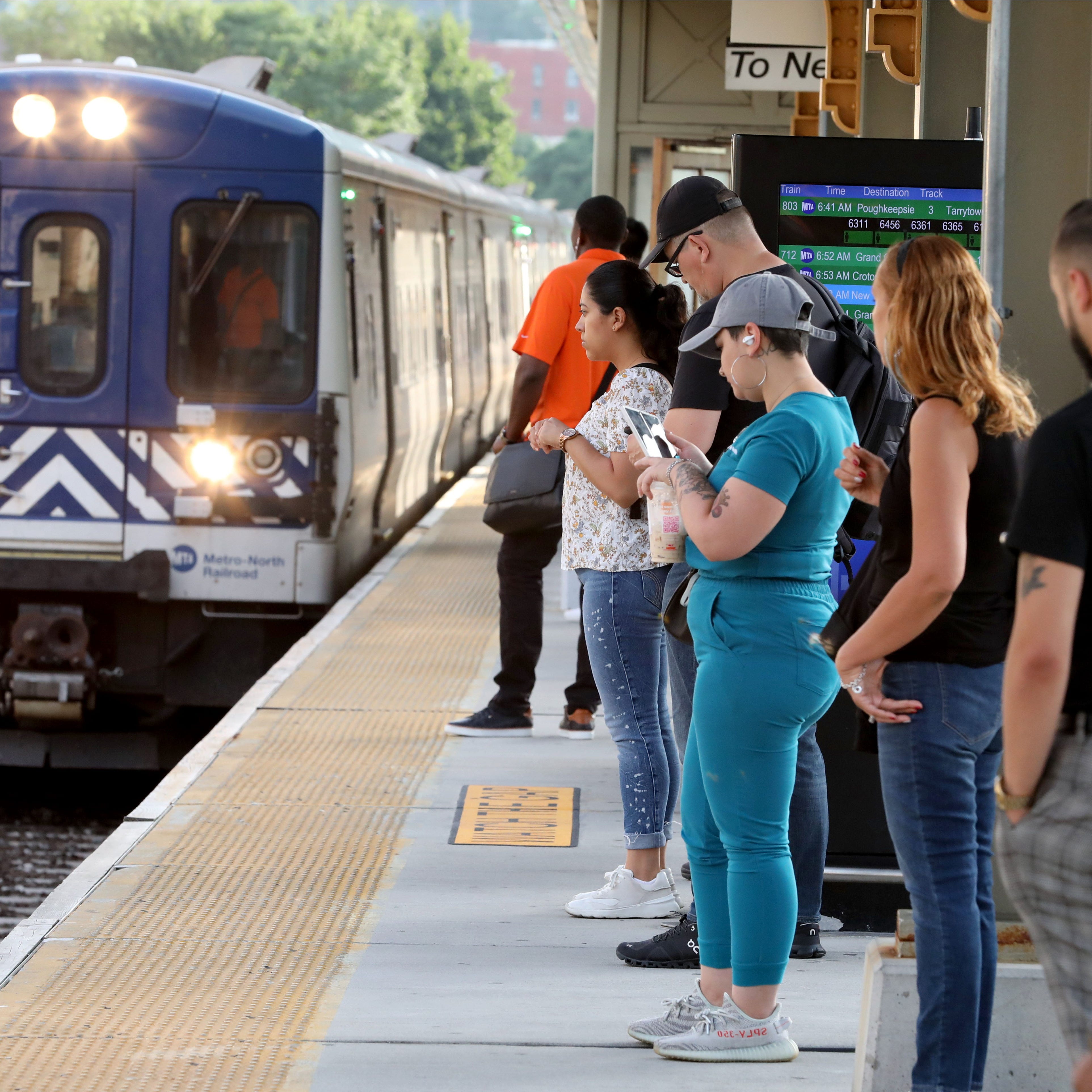 Metro-North train commuters board a southbound train at the Yonkers Metro-North train station, July 29, 2022.