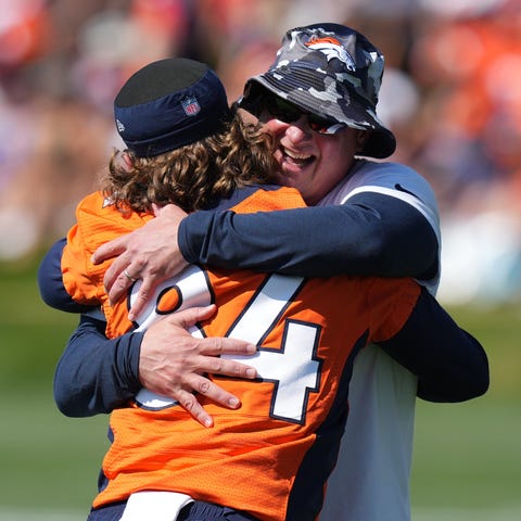 Denver Broncos head coach Nathaniel Hackett hugs w