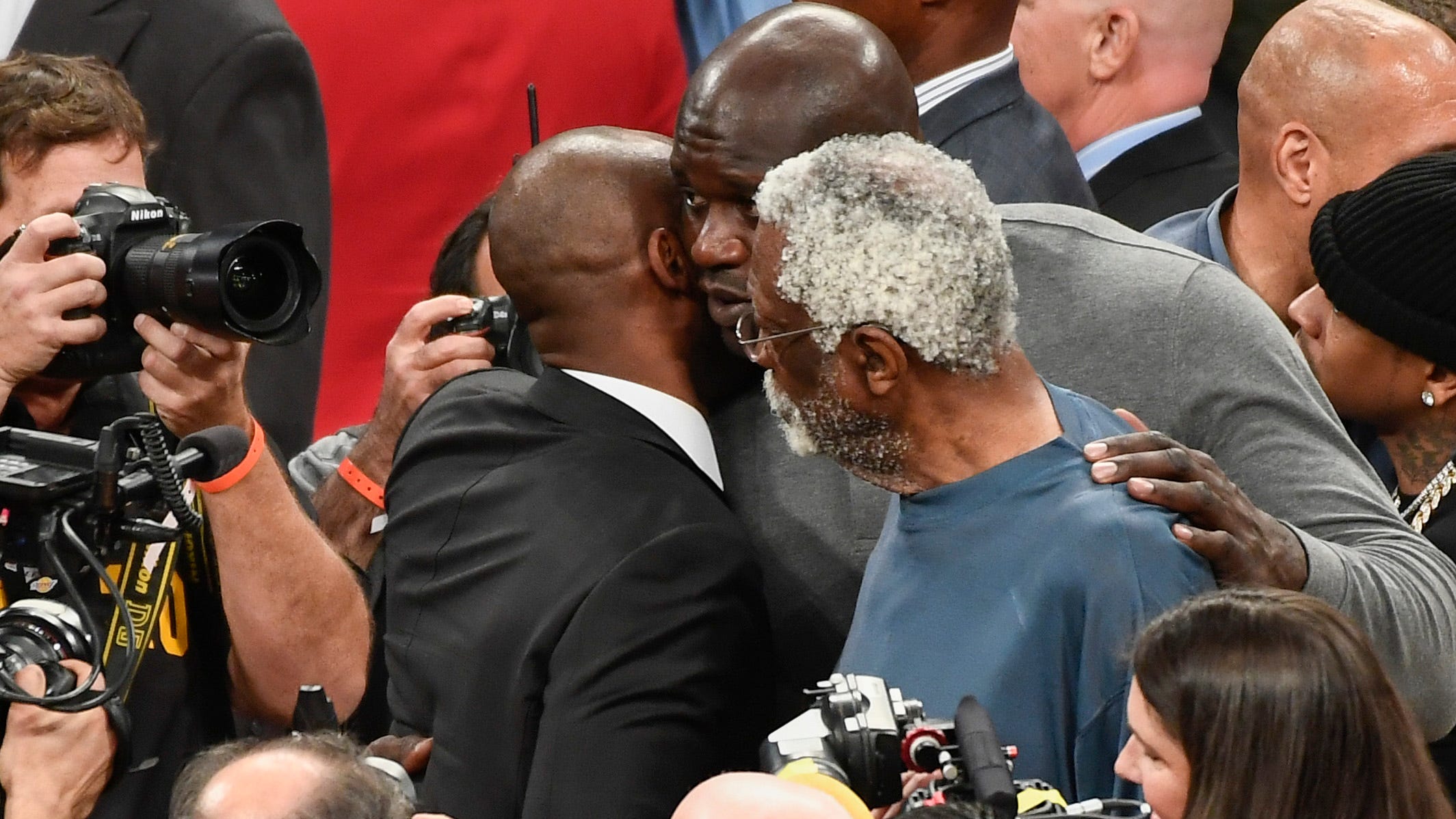 Kobe Bryant talks to Shaquille O'Neal and Bill Russell at the conclusion of a halftime ceremony to retire his two uniform numbers at Staples Center in 2017.