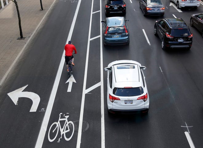 A cyclist heads north in a marked bike lane on 4th Street in downtown Columbus in this 2016 file photo.