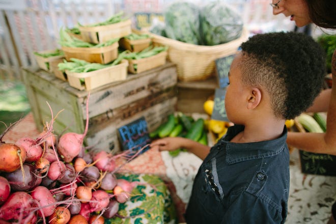 A young shopper exams the produce at East Atlanta Village Farmers Market.