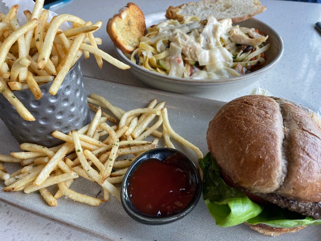 The Point (b)urger, front, is made with locally sourced beef, organic greens, vine tomato, caramelized bourbon onion jam and smoked cheddar on a multigrain bun.  It's served with fries.  Diners may add meats and proteins to the pasta primavera, back.