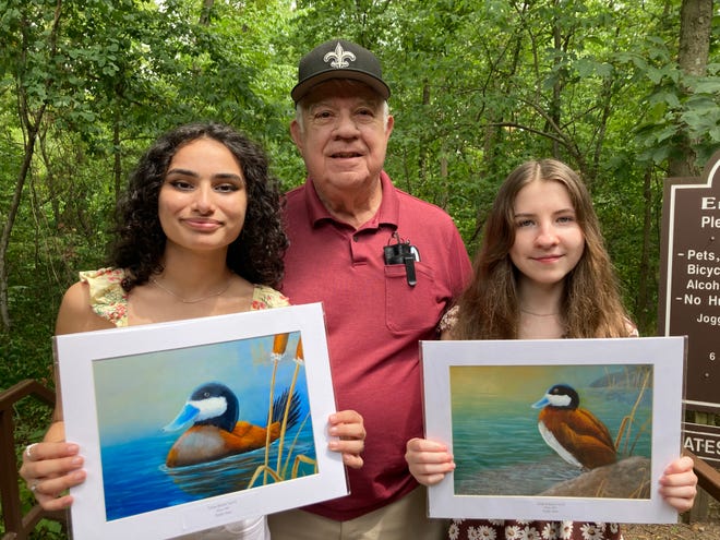 From left to right, Vivian Bashar, Greg Chappell and Aliyah Ridenour pose for a photo at the Springfield Conservation Nature Center. Bashar, 15, and Ridenour, 13, hold their painting submissions for the 2022 U.S. Fish & Wildlife Service Junior Duck Stamp Art Contest.