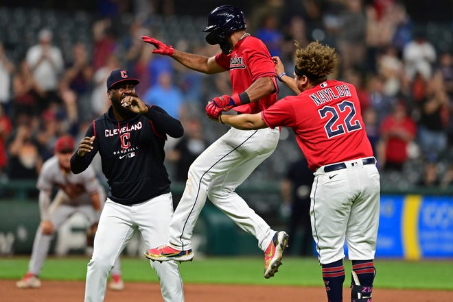 Guardians shortstop Amed Rosario, center, celebrates with Josh Naylor (22) and Franmil Reyes, left, after hitting an RBI-single in the 10th inning of a 6-5 win over the Arizona Diamondbacks on Monday night at Progressive Field. [David Dermer/Associated Press]