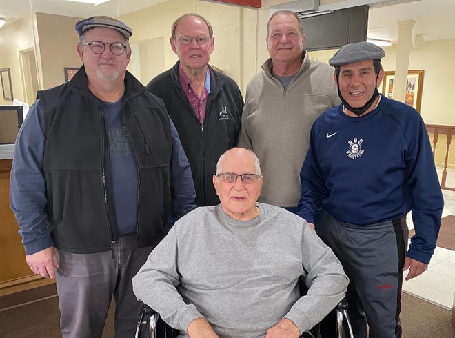 A group of former players regularly come to Monmouth to visit their Fighting Scots coach, Bill Reichow (seated). Stopping by on this January day were, from left, Paul Waszak, Monmouth mayor Rod Davies, Greg Derbak and Mike Castillo.