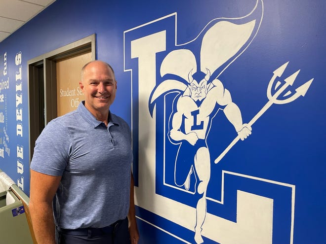 Outgoing Leominster High School Principal Steven Dubzinski stands next to the Blue Devils logo just off the school's front foyer Tuesday, July 26.