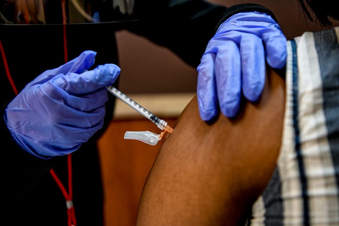 A health care worker administers a COVID-19 vaccine in 2021.