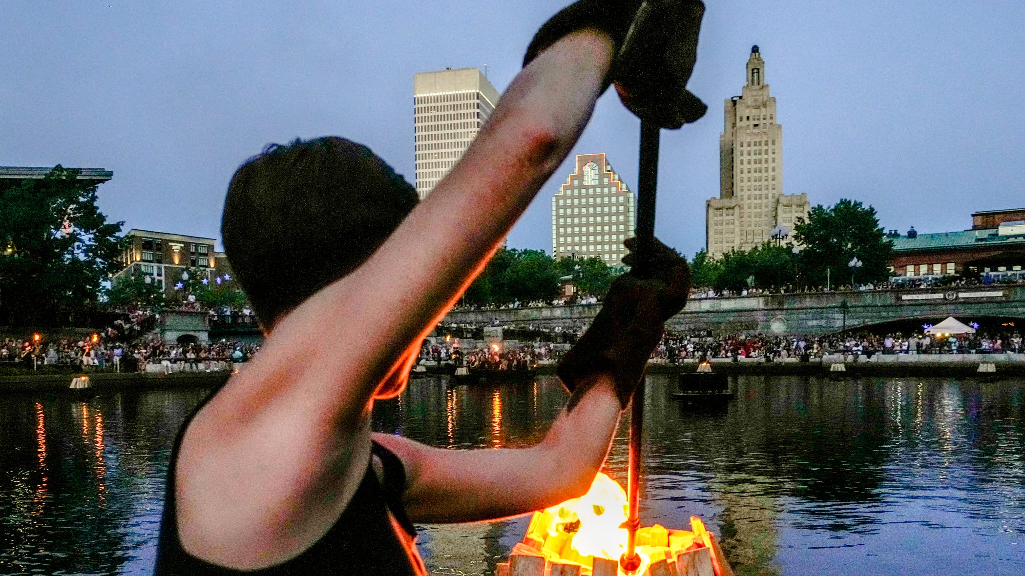 WaterFire Providence volunteers ignite braziers, tends to fire on boat
