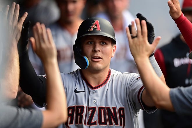 Arizona Diamondbacks' Daulton Varsho is congratulated in the dugout after hitting a solo home run off Cleveland Guardians starting pitcher Cal Quantrill during the fourth inning of a baseball game, Monday, Aug. 1, 2022, in Cleveland.