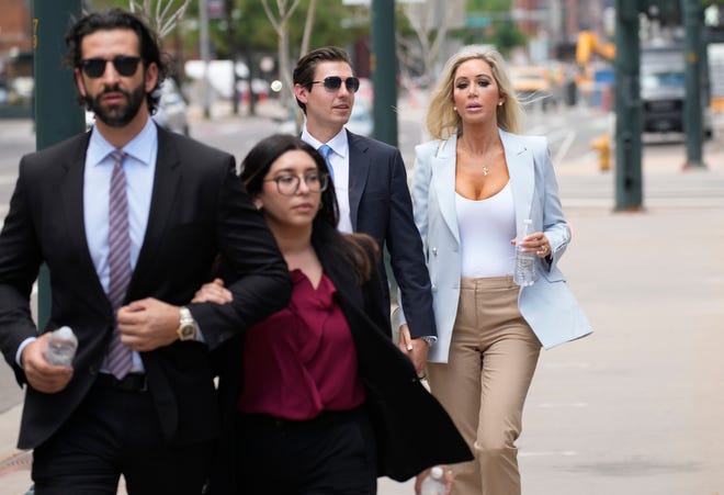 The son, left, and daughter, back right, of Pittsburgh dentist Lawrence "Larry" Rudolph head into federal court for the afternoon session of the trial, Wednesday, July 13, 2022, in Denver.