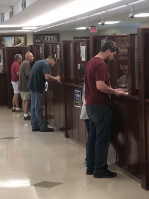 Residents wait at service windows to pay their taxes at the Columbia County Tax Commissioner's Office in Evans in this photo from 2018. The county's Board of Commissioners voted Aug. 2 to establish its annual millage rate.
