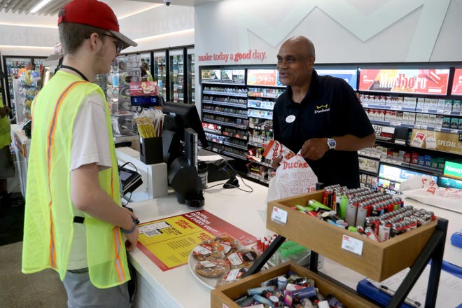 Cashier Christopher McCoy checks out customer Logan Jackson of Columbus at the newly opened Duchess convenience store Aug. 2 at 2135 Beech Road in New Albany.
