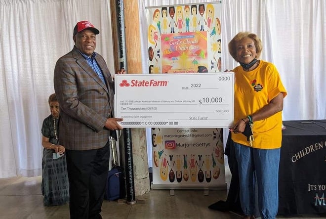 State Farm agent Anthony Gallant of Gastonia presents an oversized check for $10,000 to the African American Museum at Loray Mill and its founder Dot Guthrie.