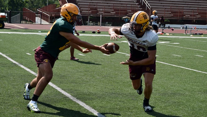Bloomington North sophomore quarterback Dash King hands off to senior running back Cody Mikulich during practice on Wednesday, August 3, 2022. (Seth Tow/Herald-Times)