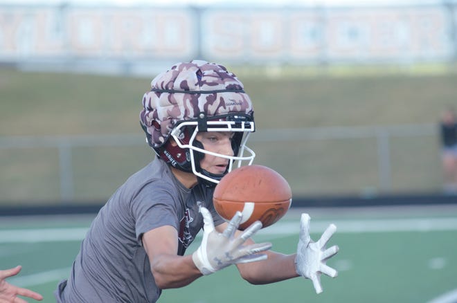 A Charlevoix receiver makes a catch while wearing a Guardian Cap, a new safety technology designed to reduce concussions in football.