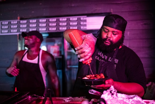 Chef D (Dionte Braxton) prepares a plate for a customer during Jerk X Jollof at Delmar in Detroit on July 21, 2022.