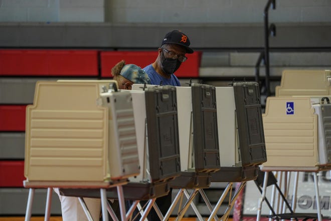 Ronald Cook, center, and Caaron Cook, of Detroit, fill out their ballots while voting for Michigan's primary elections at Detroit Collegiate Preparatory High School at Northwestern in Detroit on Tuesday, Aug. 2, 2022.