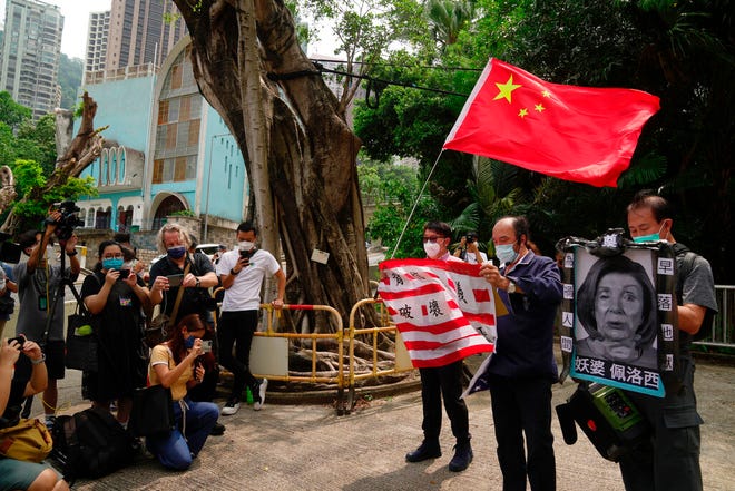 Pendukung pro-China memegang bendera AS dan gambar Ketua DPR AS Nancy Pelosi selama protes di luar Konsulat Jenderal Amerika Serikat di Hong Kong, Rabu, 3 Agustus 2022.