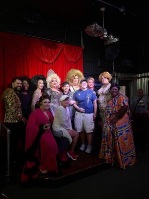 Drag queen Onya Knees wears her crown as she poses with other performers and the owners of Zonie's Closet on July 24. She will perform on Saturday.