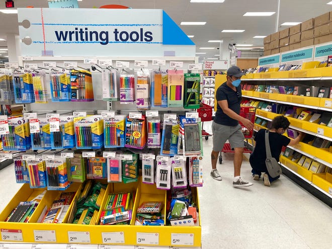 Shoppers look for school supplies deals at a Target store, Wednesday, July 27, 2022, in South Miami, Fla. This back-to-school shopping season,  parents, particularly in the low to middle income bracket,  are focusing on the basics like no frills rainboots, while also trading down to cheaper stores, including second-hand clothing, as surging inflation takes a toll on their household budgets.  (AP Photo/Marta Lavandier)
