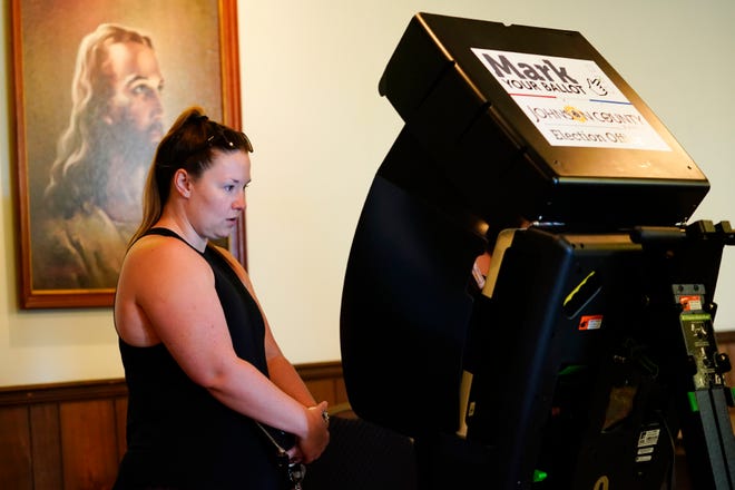 MERRIAM, KANSAS - AUGUST 02: A poll worker helps a voter cast their ballot in the Kansas Primary Election at Merriam Christian Church on August 02, 2022 in Merriam, Kansas. Voters in Kansas will decide on whether or not to remove protection for abortion from the state's constitution.