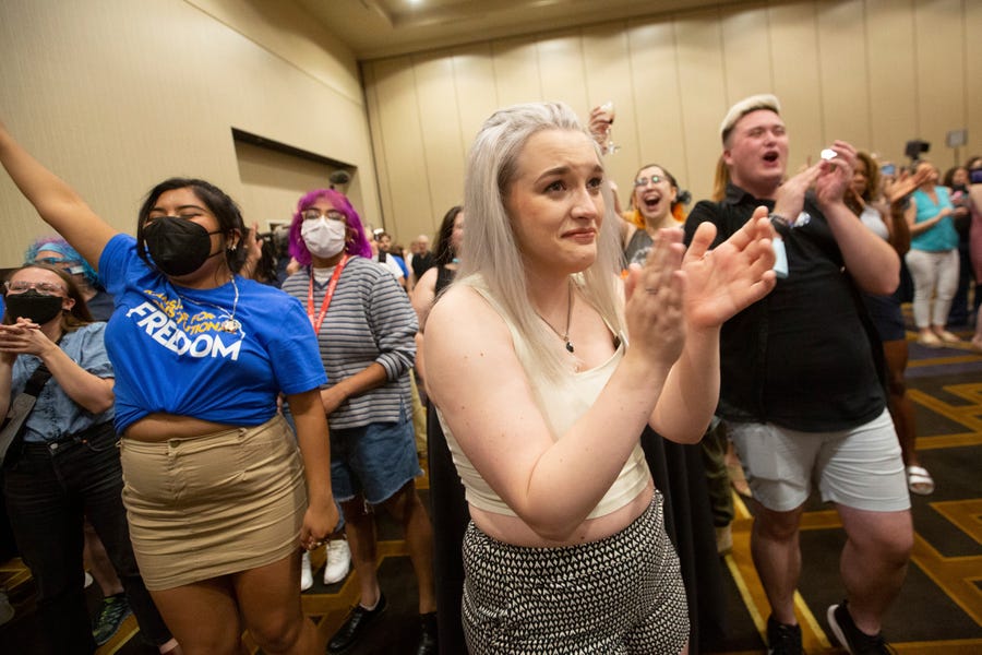 Allie Ugley, middle, an Allen County resident, holds back tears after hearing the news that the "No" votes won on a proposed amendment to the Kansas Constitution from the Kansans for Constitutional Freedom election watch party at the Overland Park Convention Center in Overland Park, Kan., Tuesday, Aug. 2, 2022. (Evert Nelson/The Topeka Capital-Journal via AP) ORG XMIT: KSTOP673