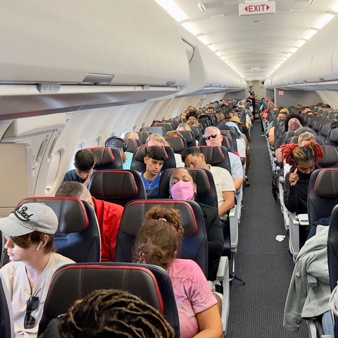 Passengers sit on board an airplane as they travel