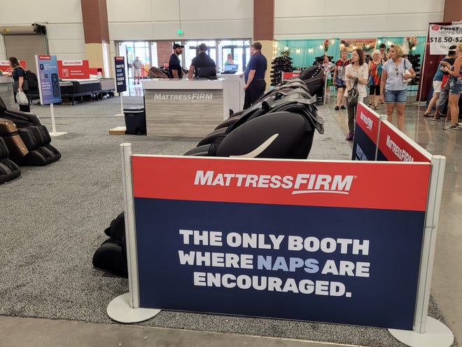 At the Mattress Firm booth in the expo hall at Wisconsin State Fair, people are invited to relax in massage chairs and mattresses.