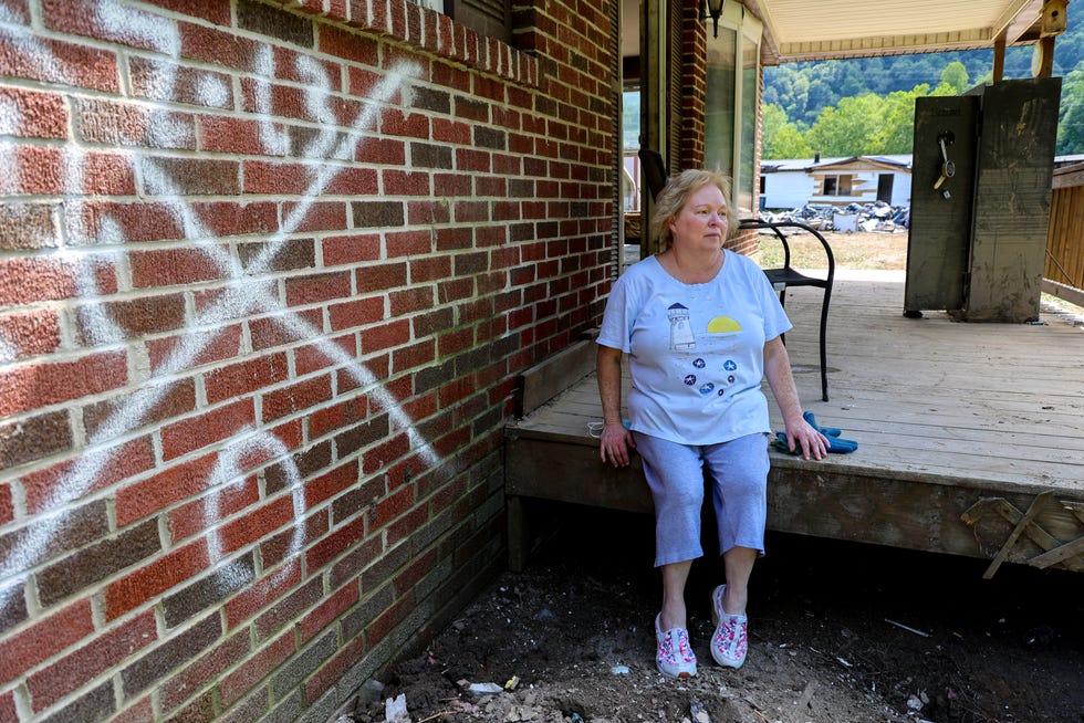 In Pilgrim’s Knob, Virginia, Sherry Honaker, 55, oversees the removal of debris from her niece's home on Dismal Creek. It was gutted in a major flood two weeks earlier - the county’s second this year.