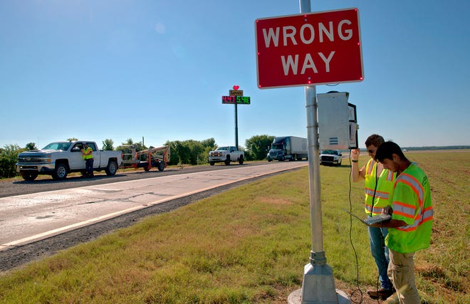 A highway worker is shown testing a new lit-up wrong way sign along Interstate 40 in east Oklahoma.