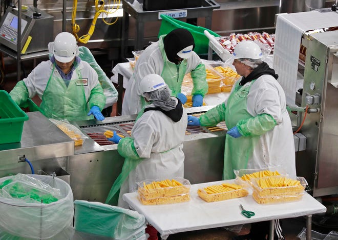 Workers at Old Wisconsin Sausage assemble sausage and cheese packets on the line, Wednesday, July 27, 2022, in Sheboygan, Wis.