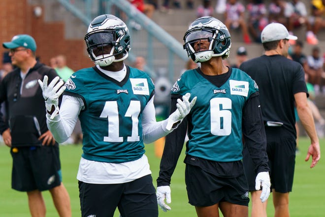 Philadelphia Eagles' A.J. Brown, left, reacts with DeVonta Smith, right, during practice at NFL football team's training camp, Wednesday, July 27, 2022, in Philadelphia. (AP Photo/Chris Szagola)