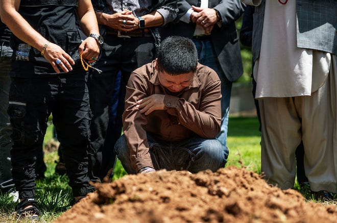 Altaf Hussein cries over the grave of his brother Aftab at Fairview Memorial Park in Albuquerque, NM, on Aug. 5. A funeral service was held for Aftab Hussein, 41, and Muhammad Afzaal Hussain, 27, at the Islamic Center of New Mexico. Both men were fatally shot near their homes six days apart.