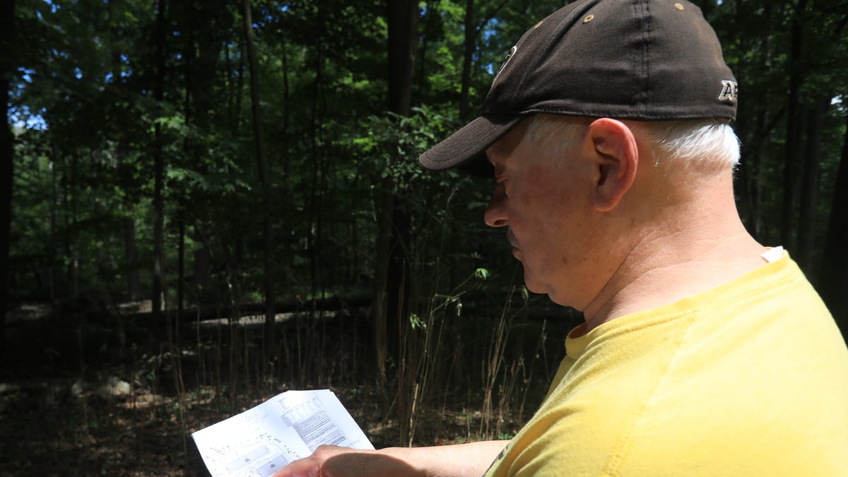 Jerry Brauer looks over a proposed plan to build 60 foot tall warehouses behind his home in Cornwall on August 5, 2022. 