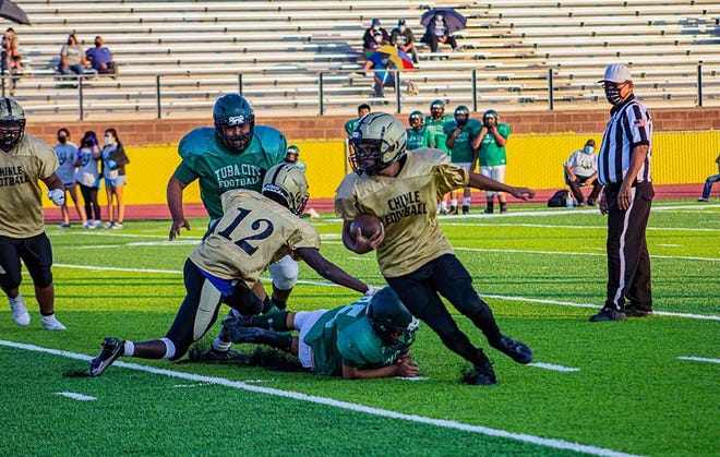Chinle quarterback Zacharian Toadlena escapes a tackle against the Tuba City Warriors on August 20, 2021.
