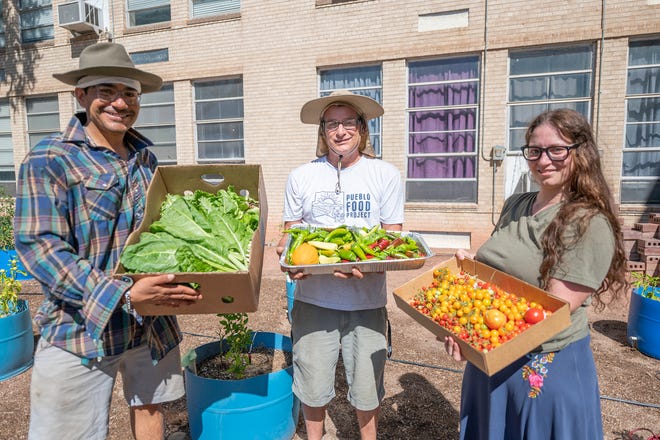 Mark Montoya, left, Deric Stowell, and Allison Rea show off the day's harvest of vegetables at the Rocky Mountain Service, Employment and Redevelopment community garden in Pueblo on Aug. 6, 2022.